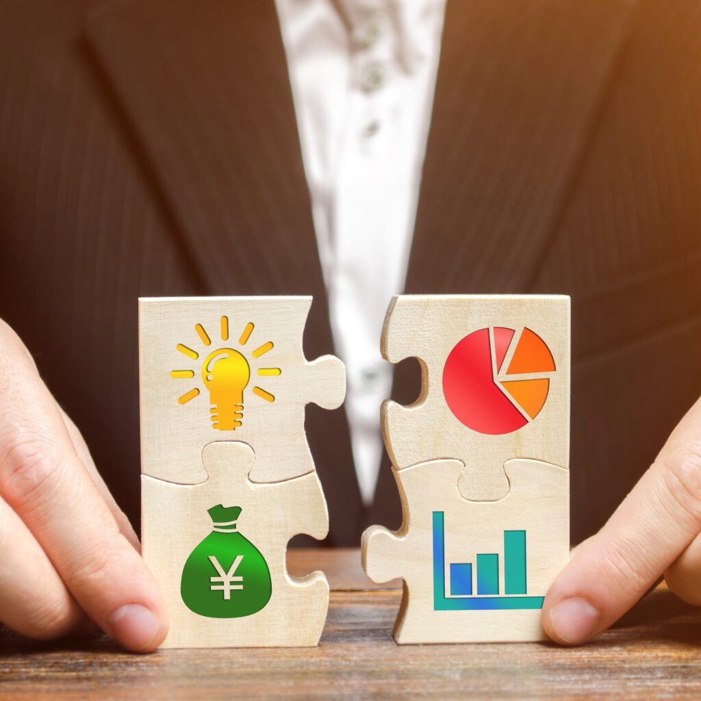 Businessman collects puzzles with the image of the attributes of doing business